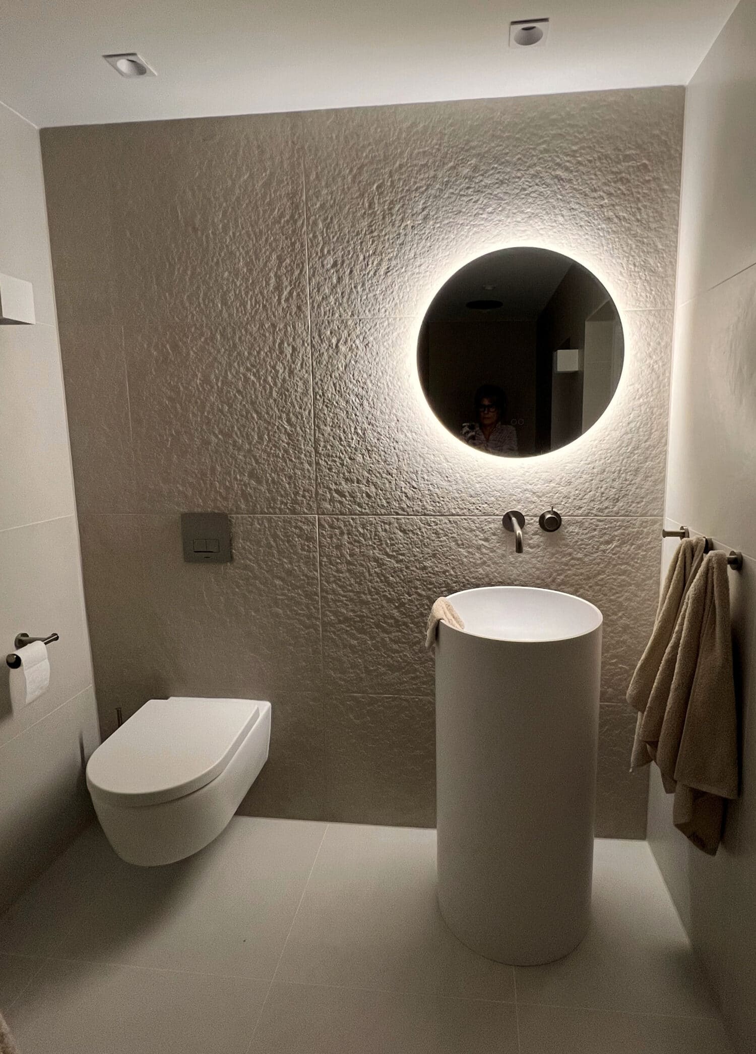 Ronde spiegel op vierkanten zandkleurige tegel