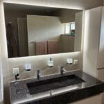 120 cm spiegel met rondom verlichting op zandkleurige tegel wand