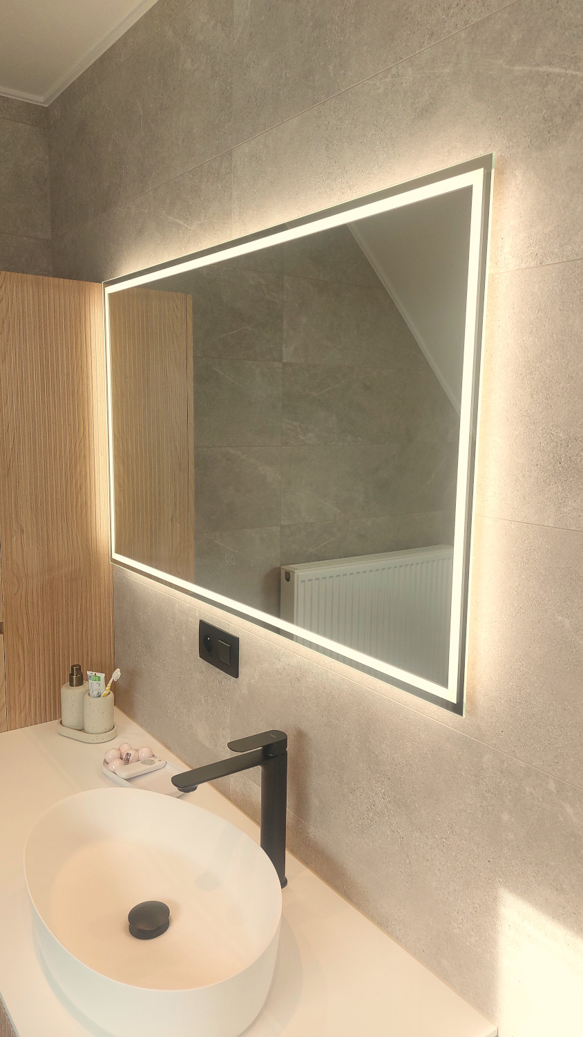 Miroir salle de bain moderne avec éclairage périphérique sur un mur de carrelage gris