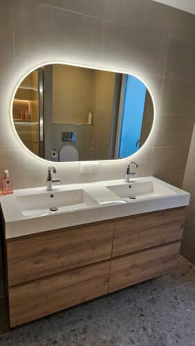 Miroir salle de bain ovale sur carrelage couleur sable