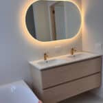Miroir salle de bain ovale sur mur blanc stuqué