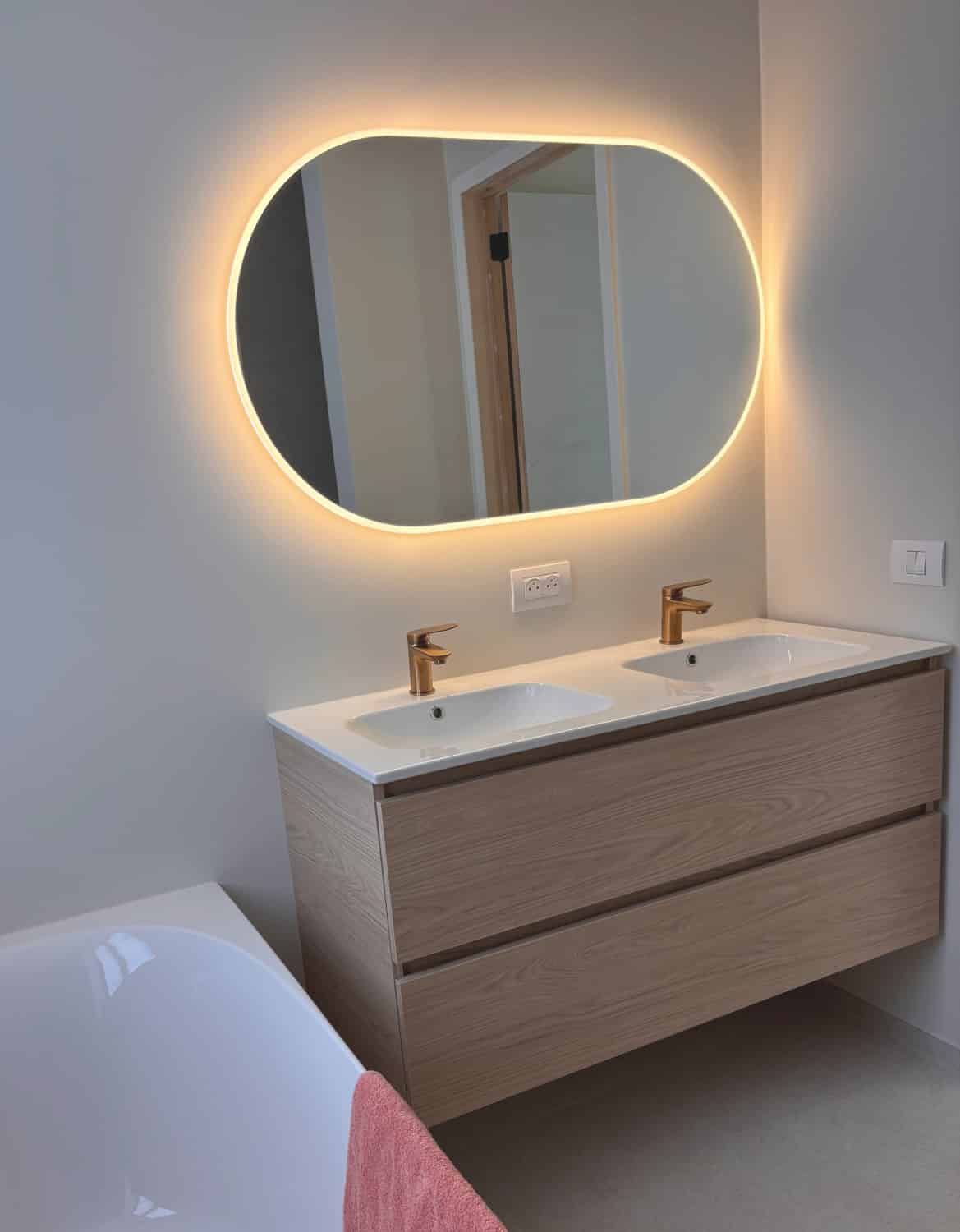Miroir salle de bain ovale sur mur blanc stuqué