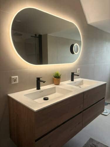 Miroir salle de bain ovale sur mur de carrelage couleur sable