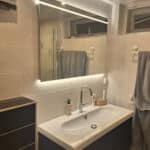 Trendy badkamerspiegel op crème kleurige tegels