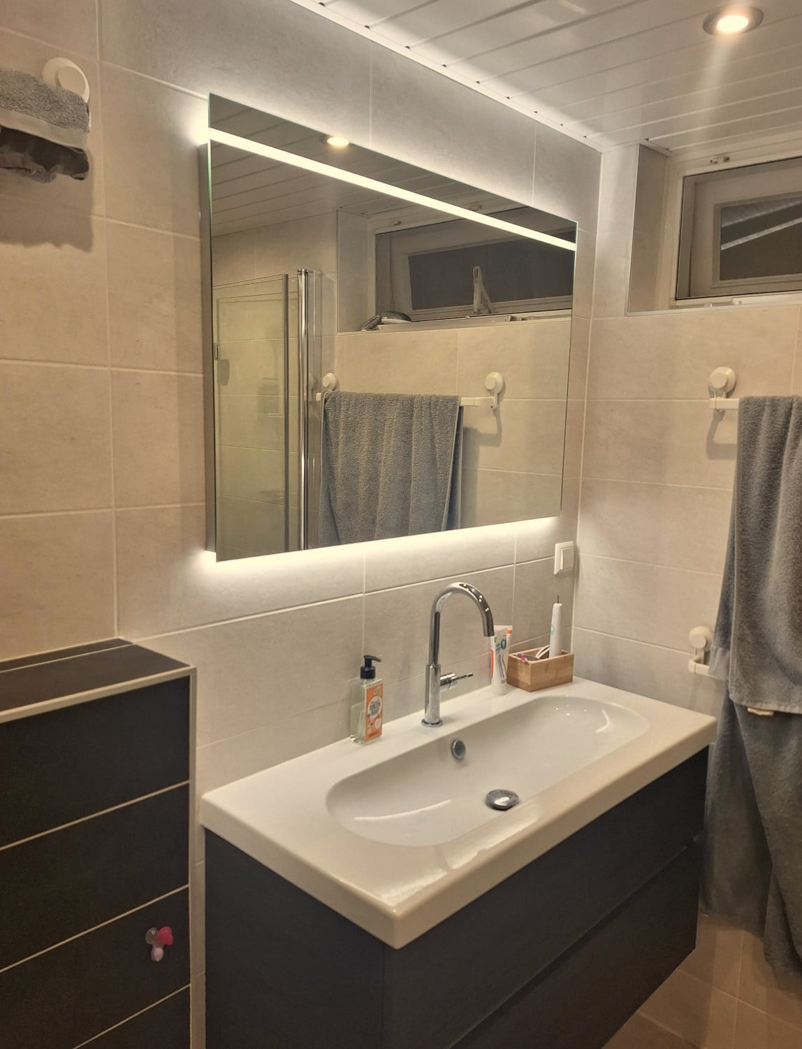 Trendy badkamerspiegel op crème kleurige tegels