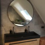 Ronde spiegel met zwarte rand in Grijze badkamer met zwarte details