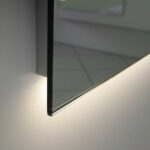 De indirecte verlichting aan de onderzijde (strijklicht) schijnt sfeervol over de wand en het badmeubel