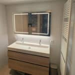 Rechthoekige spiegelkast op witte tegelwand