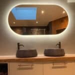 Ovale badkamer spiegel op gestuukte wand