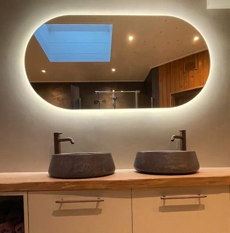 Ovale badkamer spiegel op gestuukte wand