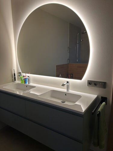 Half ronde badkamer spiegel op wit gestucte wand