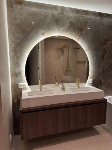 Halfronde badkamerspiegel op marmeren wand