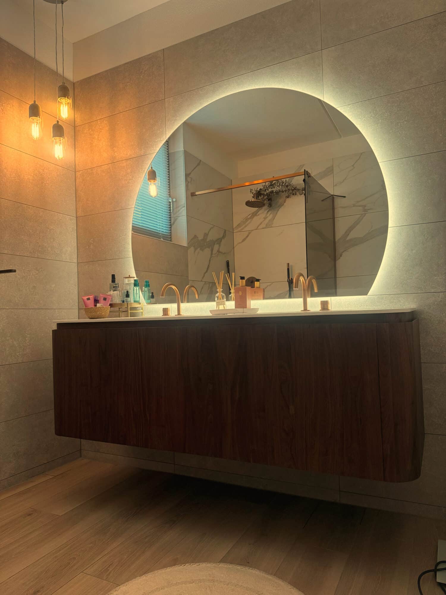 Organische spiegel boven een badkamermeubel met afgeronde hoeken