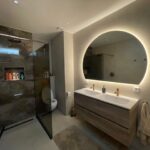 Ondergaande zon badkamer spiegel op zandkleurige tegel