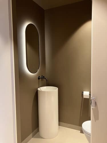 Ovale toilet spiegel op gestuukte wand