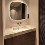 Deens ovale spiegel op zandkleurig gestuukte wand