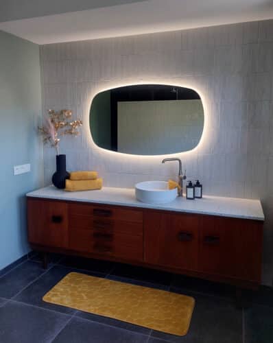 Deens ovale spiegel op wand met witte verticale tegels