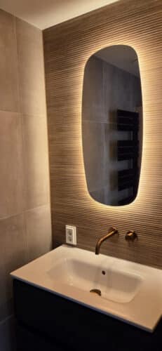 Miroir ovale sur carrelage nervuré