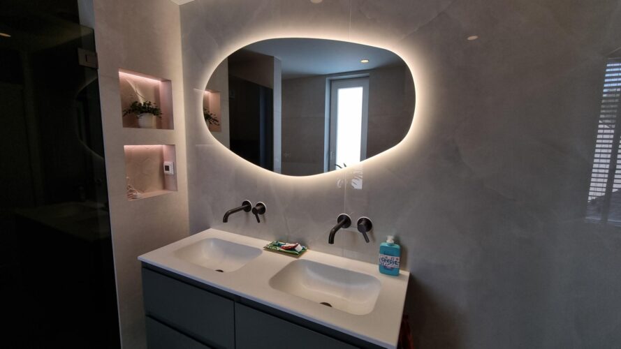 Miroir salle de bain organique sur grand carrelage en marbre