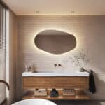 Deze trendy badkamer spiegel met organische vorm is 120 cm breed, 70 cm hoog en slechts 3 cm diep