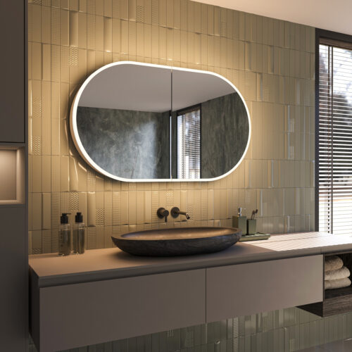 Deze fraaie ovale spiegelkast van aluminium is van alle gemakken voorzien, zoals: geïntegreerde verlichting, spiegelverwarming in de deuren, 2 geaarde stopcontacten, soft-close scharnieren en traploos verstelbare glazen plankjes