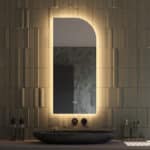 Deze 45 cm brede asymmetrische badkamerspiegel is van alle gemakken voorzien, zoals: geïntegreerde verlichting, spiegelverwarming, dubbele touch schakelaar met dimfunctie en instelbare lichtkleur